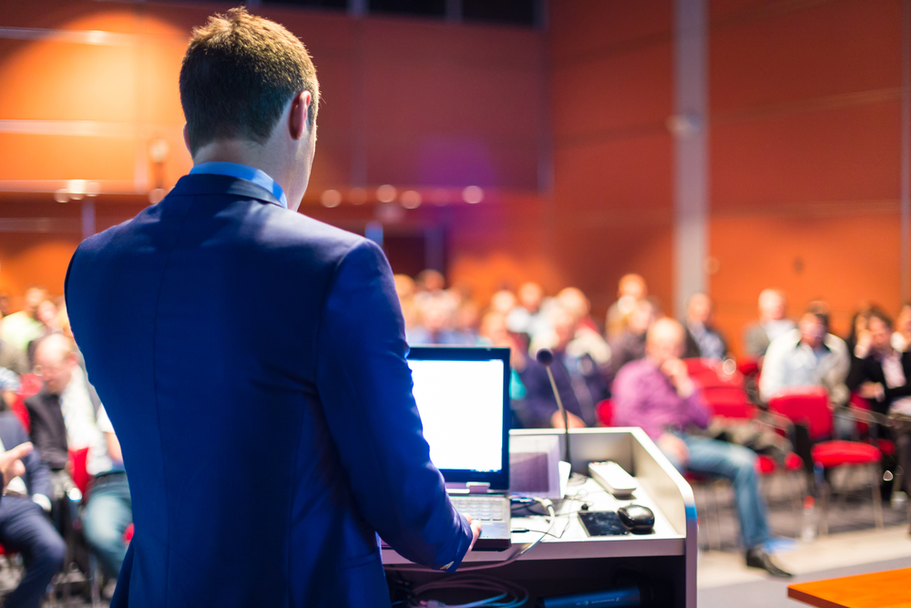 Real estate coaches Man speaking to a large room