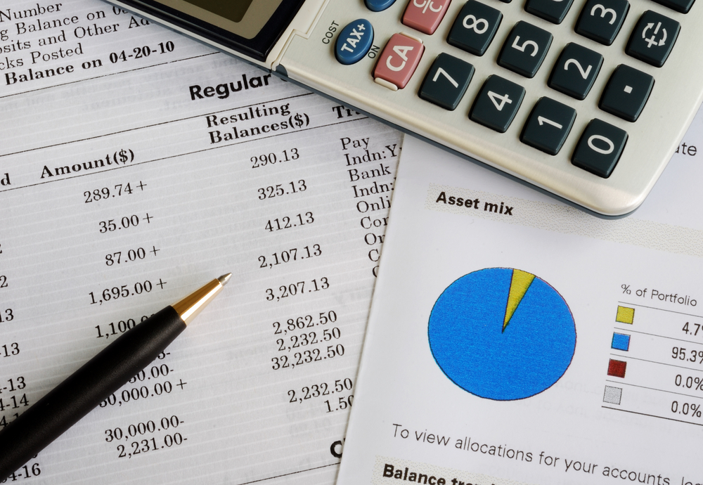 Pass on your real estate portfolio Investing documents scatterd on a table with pen and calculator