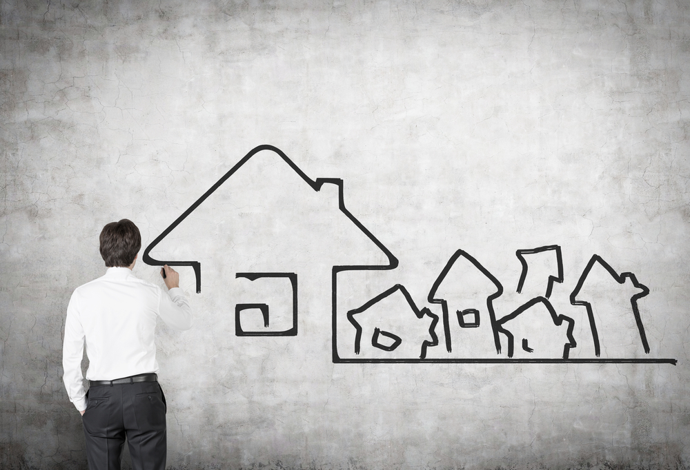 real-estate-content-marketing Man drawing houses on white board.