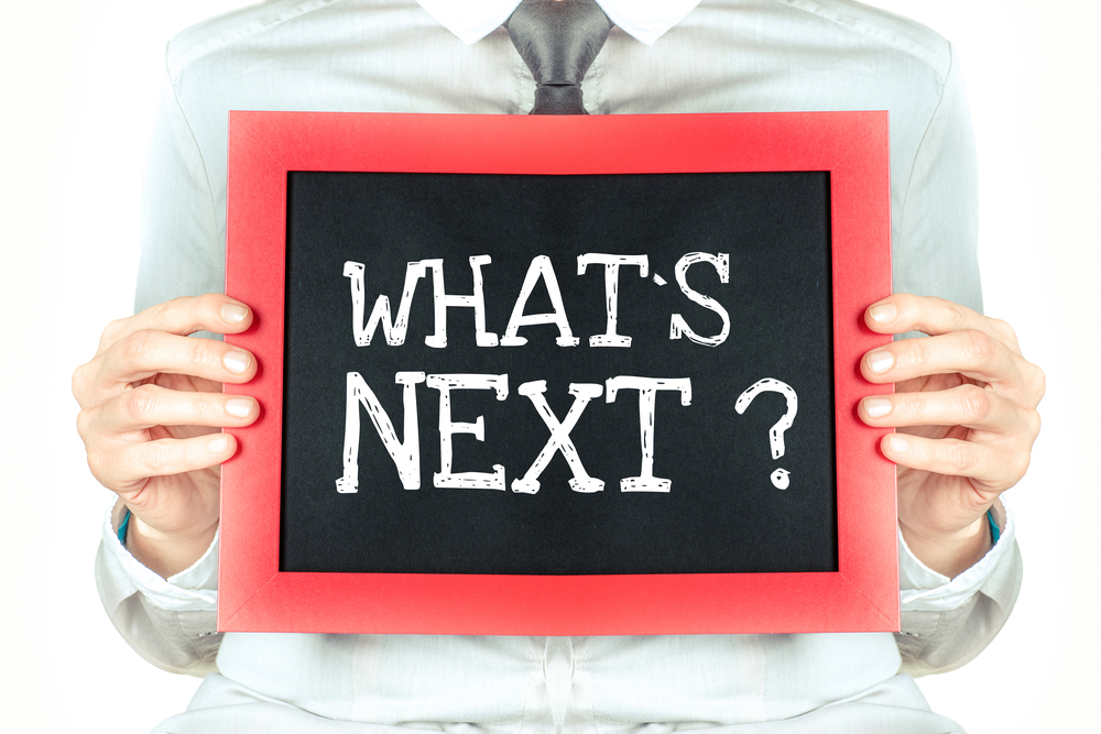 whats-next Man holding chalk board that says "what's next"