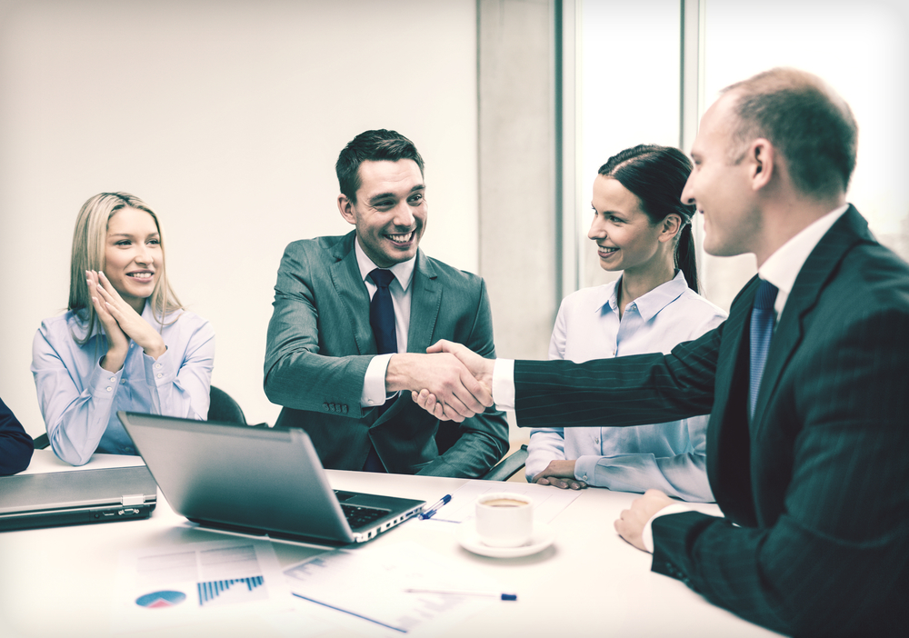 sales-team Men shaking hands at table.