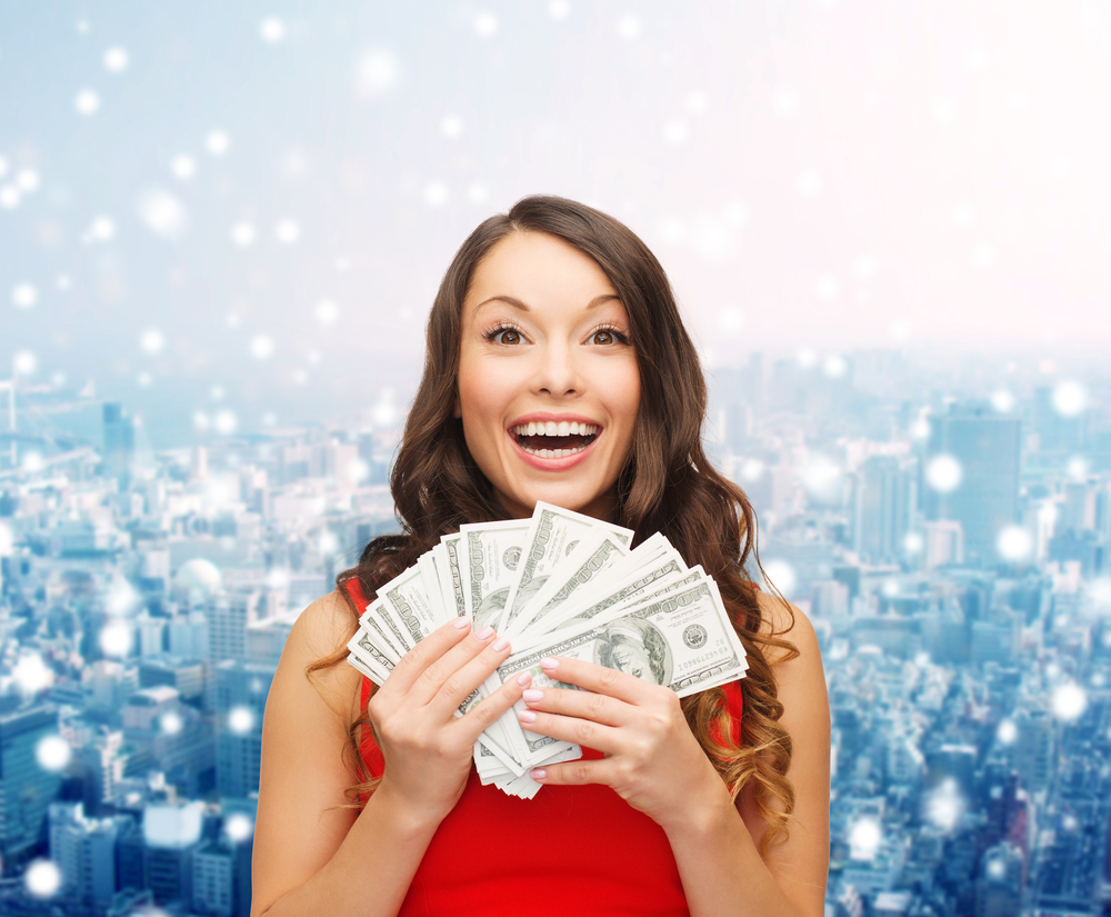 shutterstock_219848458 Woman holding a lot of money